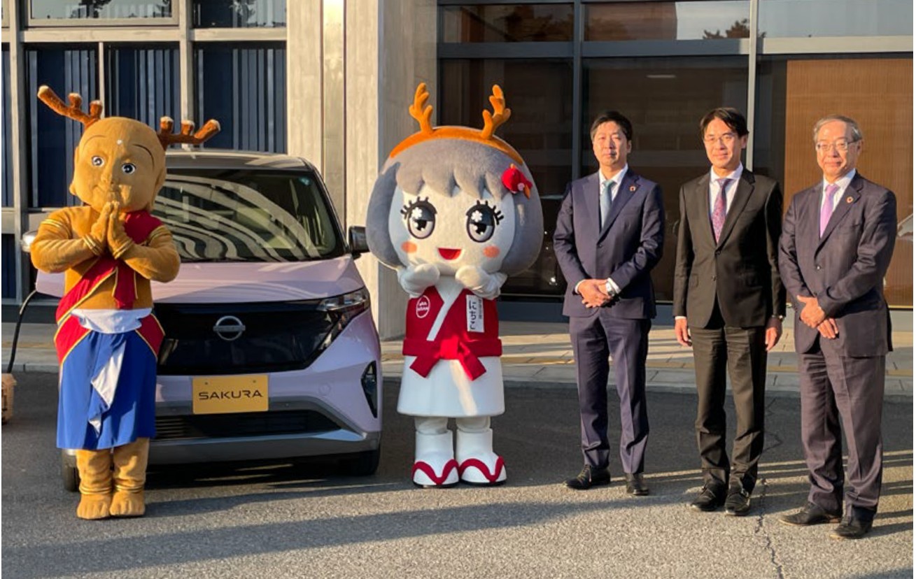 連携協定の発表に集まった関係者と、日産サクラ、せんとくん、なら にちこ。